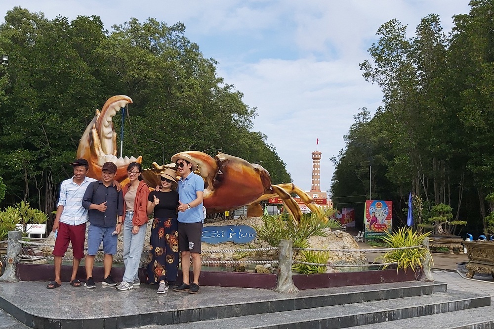 Du khách chụp ảnh lưu niệm tại biểu tượng con cua ở Khu du lịch quốc gia Mũi Cà Mau