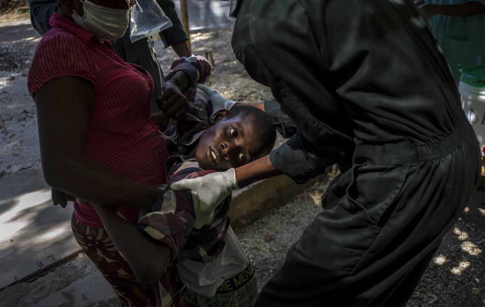 Một thanh niên bị các triệu chứng của bệnh tả được giúp đỡ khi đến bệnh viện do Tổ chức Bác sĩ Không Biên giới điều hành ở Port-au-Prince, Haiti, Thứ Năm, ngày 27 tháng 10 năm 2022. 