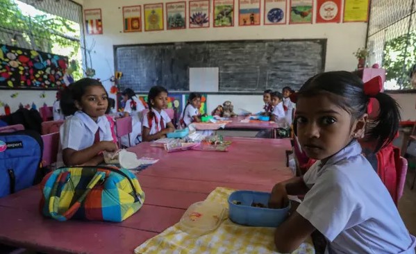 Học sinh Sri Lanka ăn sáng trong lớp học tại một trường học ở Colombo; một số trường đang cố gắng cho học sinh ăn. Ảnh: Chamila Karunarathne / EPA