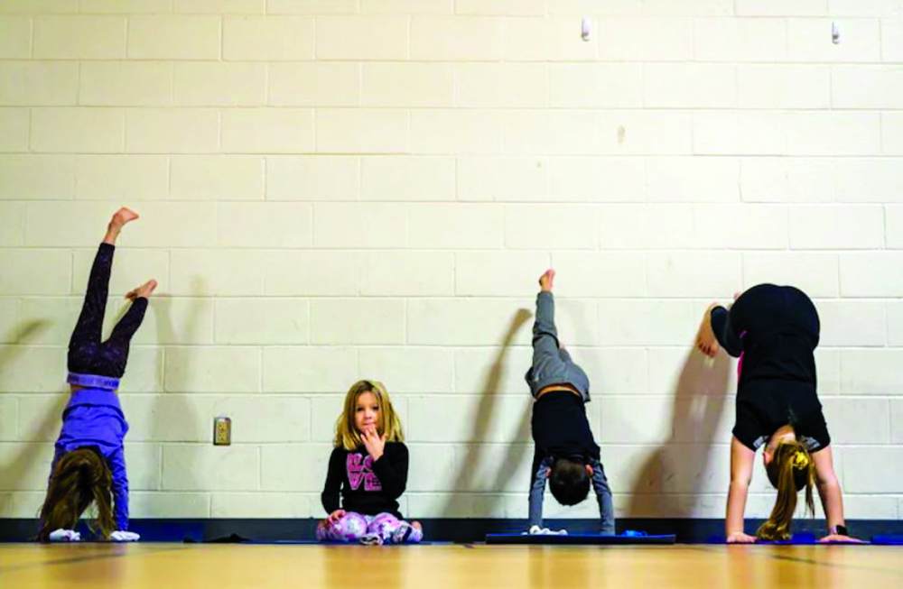 Bé Sonia Quinones (5 tuổi) xem mọi người tập yoga tại Trường tiểu học Cherry Run, Burke ẢNH: THE WASHINGTON POST