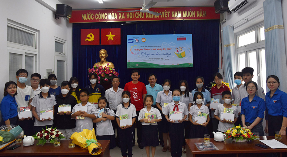 Đại diện các đơn vị tài trợ và Ủy ban Mặt trận Tổ quốc Việt Nam quận 8 chụp ảnh cùng các em học sinh nhận học bổng. Ảnh: Hoàng Hà