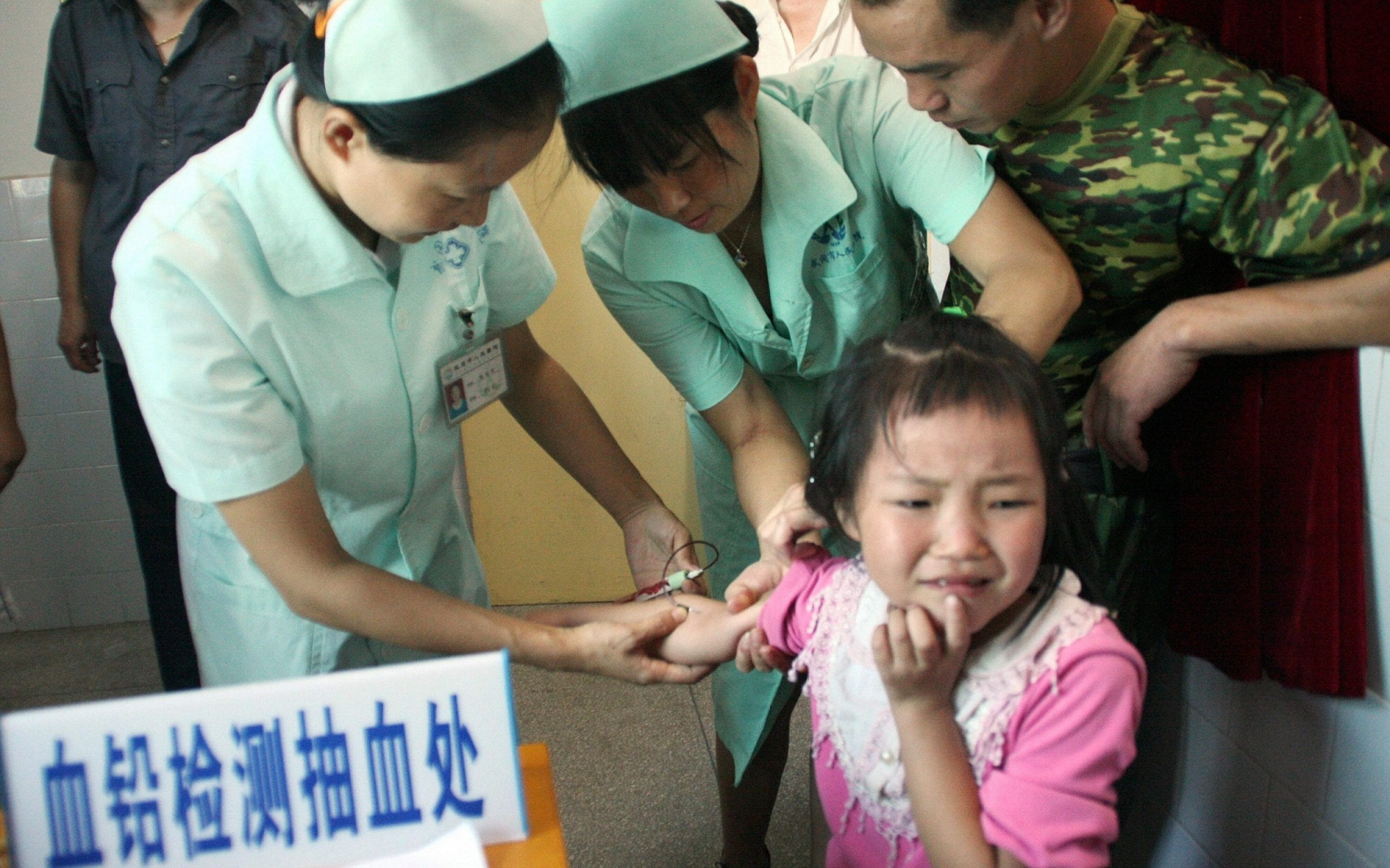 Một bé gái tại Trung Quốc đang được lấy mẫu kiểm tra nồng độ chì trong máu. (Ảnh: AFP)