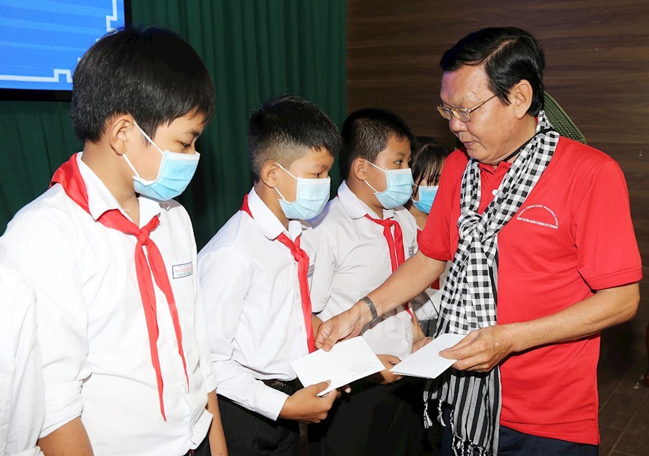 Ông Nguyễn Tấn Phong trao quà cho các em học sinh có hoàn cảnh khó khăn, học giỏi. Ảnh: TU