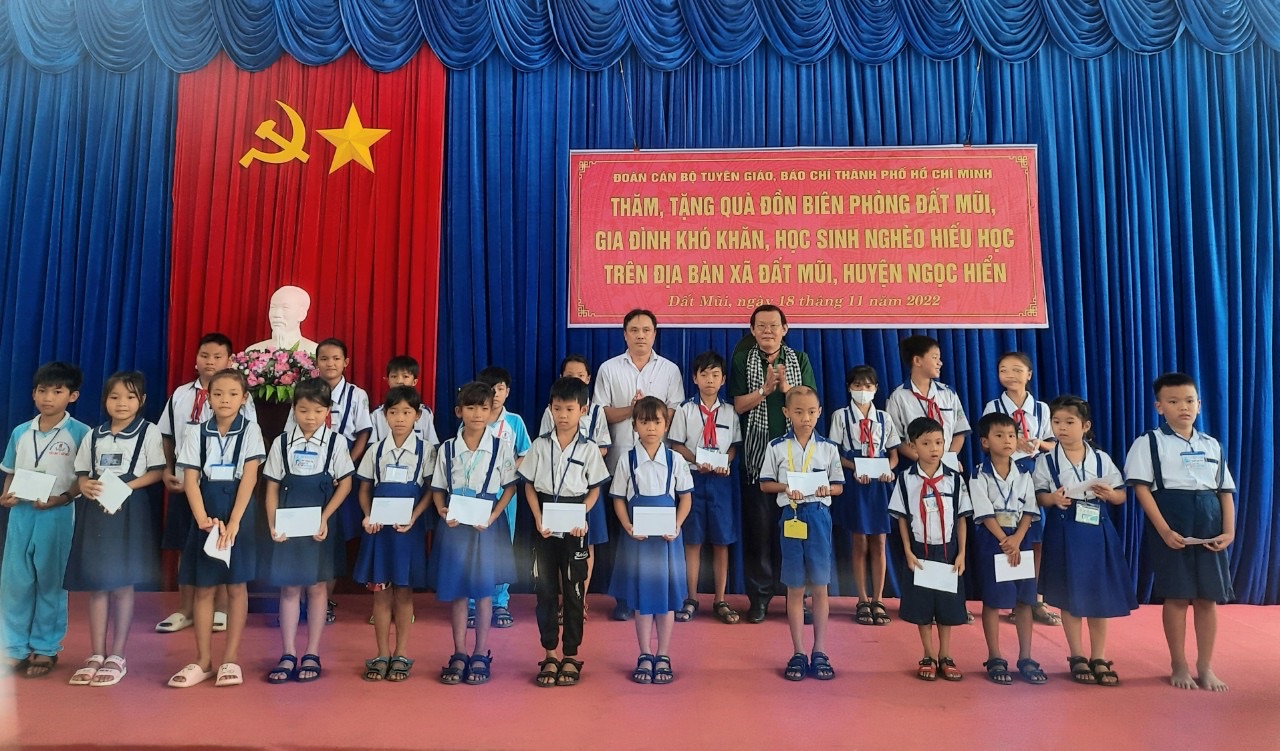 Chủ tịch Hội Nhà báo TPHCM Nguyễn Tấn Phong tặng quà cho các em học sinh nghèo hiếu học xã Đất Mũi, huyện Ngọc Hiển, tỉnh Cà Mau. Ảnh: ĐPN