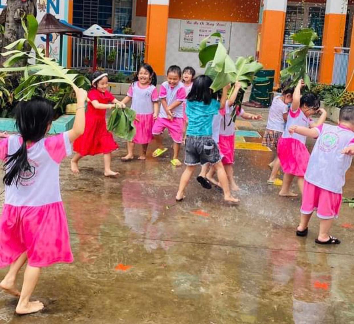 Các em học sinh được thoải mái tắm mưa, vui chơi trong sân trường