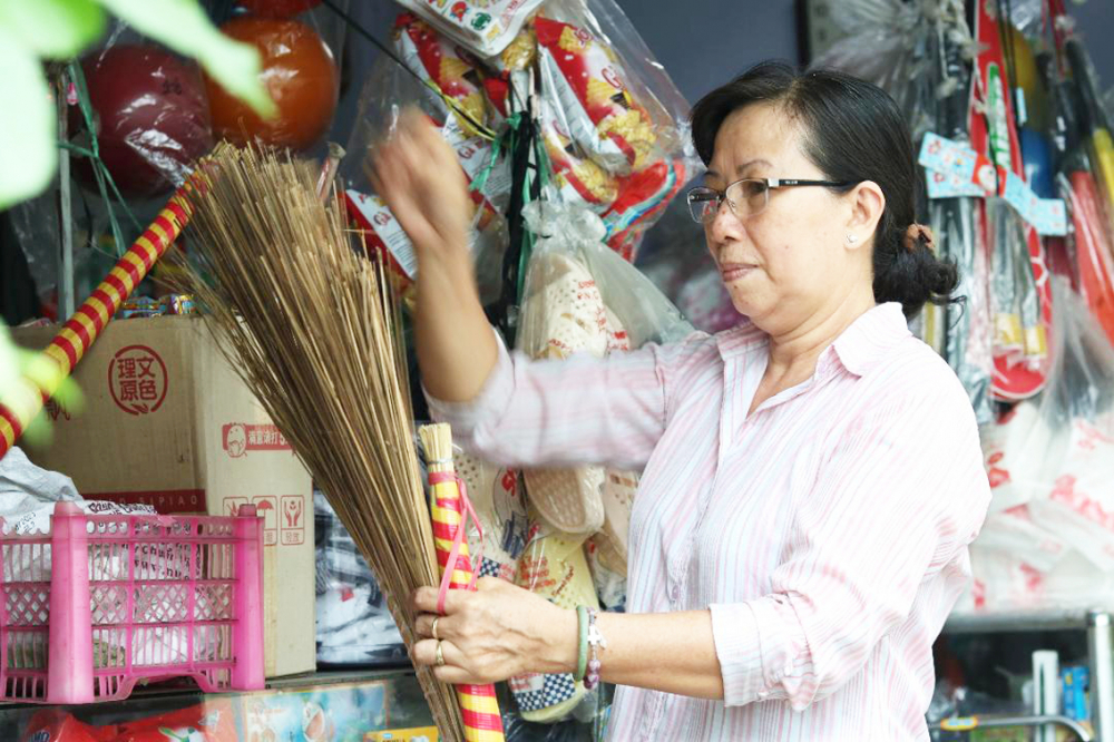 Bà Nguyễn Thị Phụng chăm chút hàng trong tiệm tạp hóa của gia đình