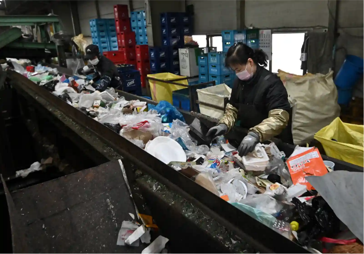 Công nhân đang phân loại rác thải tại nhà máy sau khi thu gom từ những thùng đựng rác tập thể đặt tại các khu dân cư - Ảnh: Jung Yeon-Je/AFP/Getty Images
