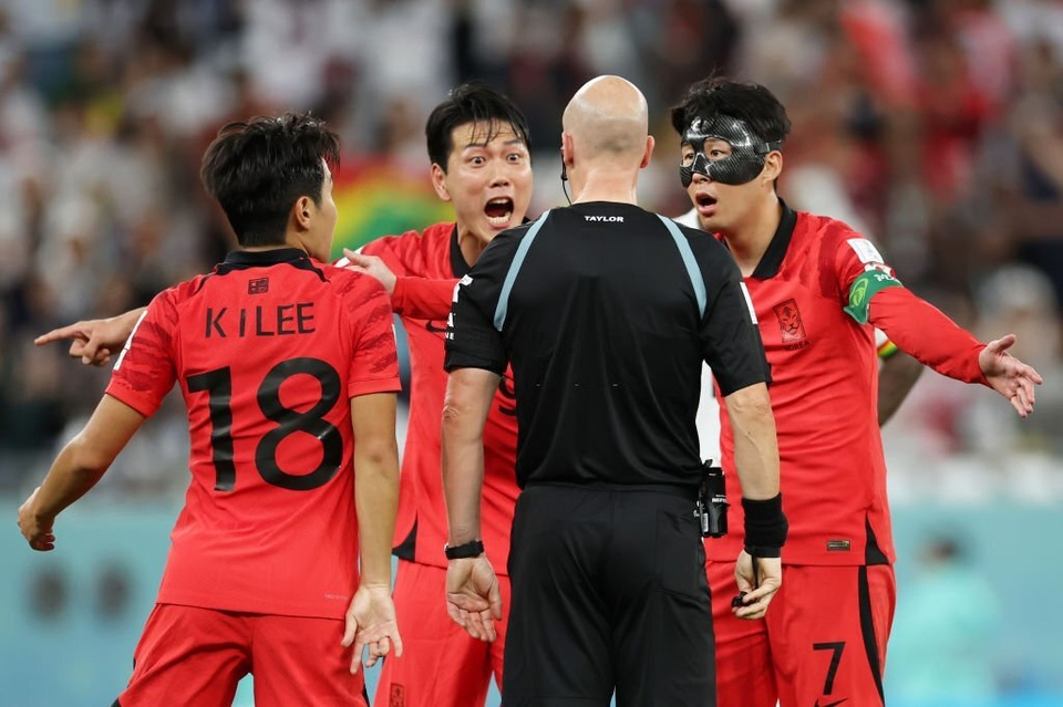 Cầu thủ Hàn Quốc vây quanh trọng tài thể hiện sự bất bình. Ảnh: Reuters