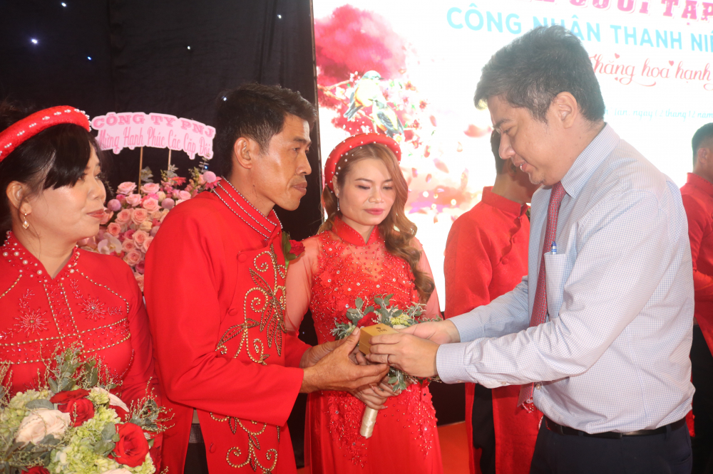 Ông Nguyễn Việt Quế Sơn - Phó bí thư thường trực Quận ủy quận Bình Tân - trao nhẫn cưới cho các cặp đôi. 