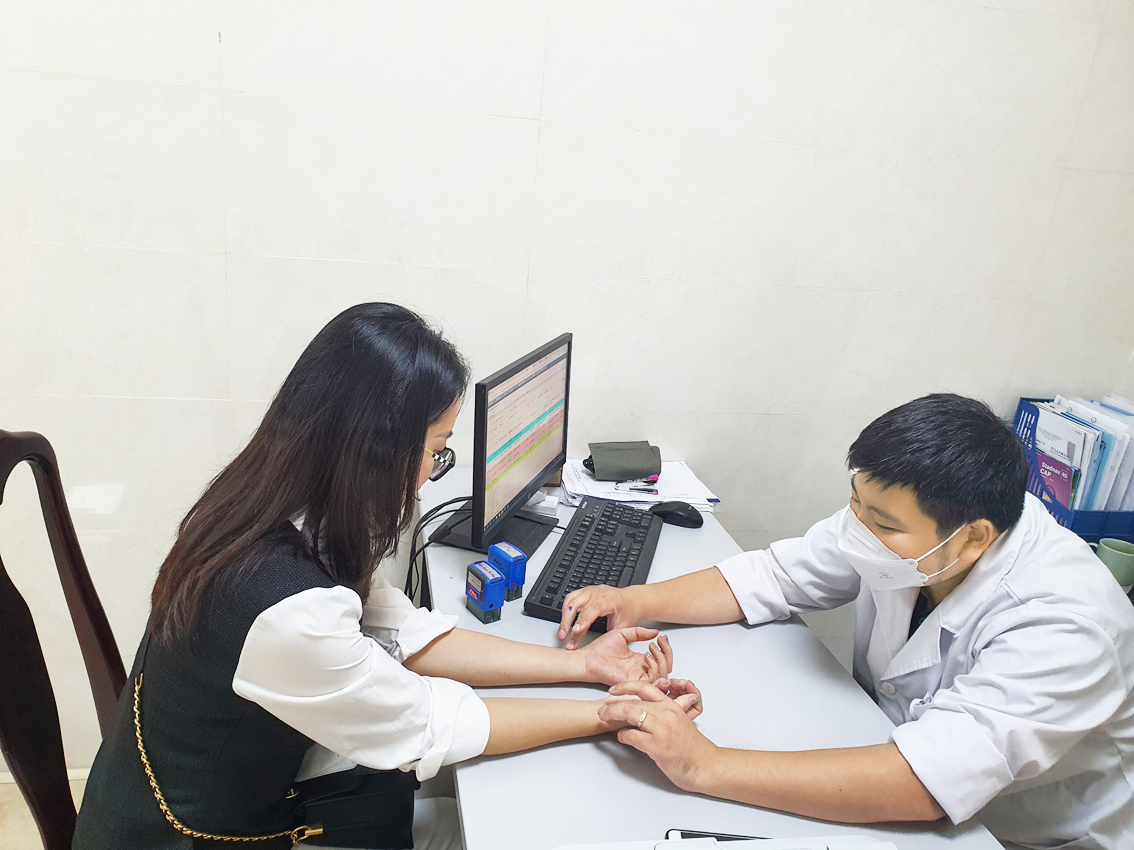 Bác sĩ Nguyễn Tiến Dũng đang khám cho một bệnh nhân bị liệt mặt - ẢNH: M.QUANG 