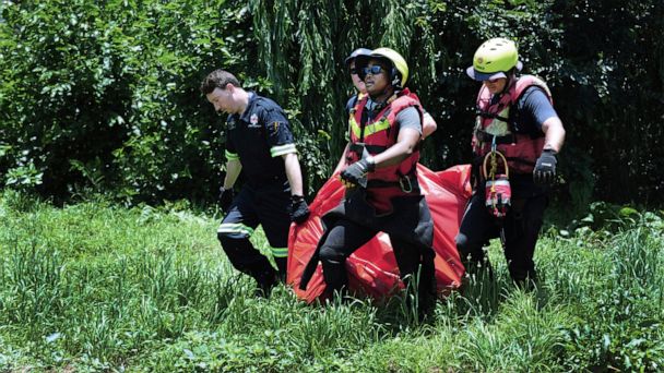 Lực lượng cứu hộ mang thi thể của một nạn nhân lũ lụt được vớt lên từ sông Jukskei ở Johannesbu...