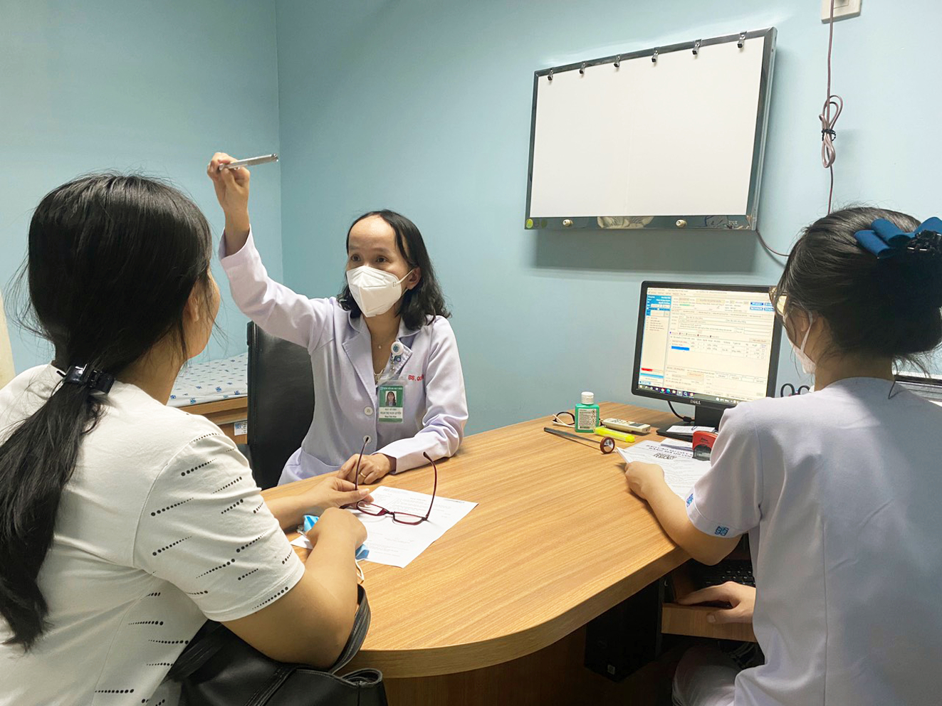 Bác sĩ  Phạm Thị  Ngọc Quyên  đang khám cho một trường hợp run tay ở người trẻ  - ẢNH: M.T
