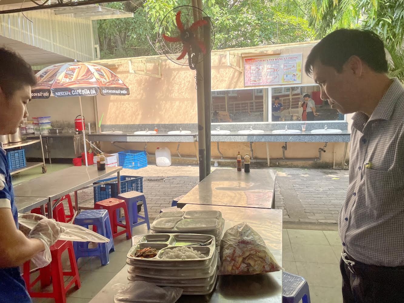 Hiệu trưởng Trường THCS Lê Văn Tám (quận Bình Thạnh) kiểm tra bữa ăn bán trú của học sinh trước giờ ăn của học sinh 