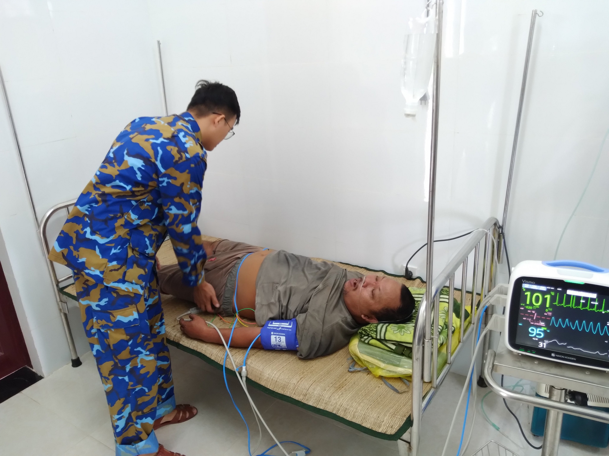 Quân y của đảo thăm, khám cho bệnh nhân Hửu - Ảnh: Nguyễn Cao