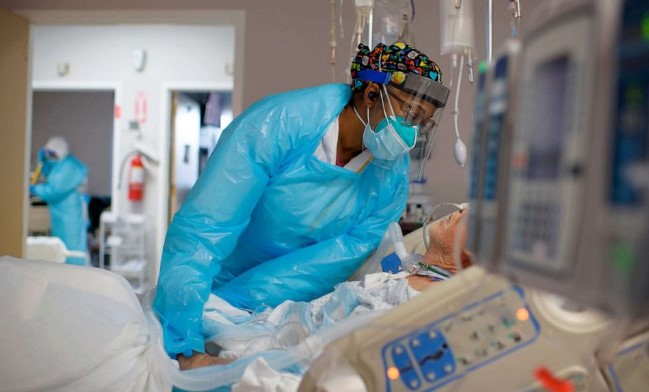 Nhân viên y tế Demetra Ransom an ủi một bệnh nhân trong khu điều trị Covid-19 tại Trung tâm Y tế United Memorial ở Houston, ngày 4 tháng 12 năm 2020.