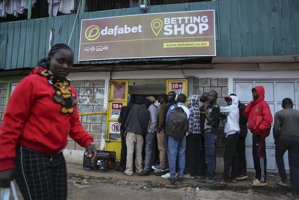 Khách hàng xếp hàng bên ngoài một cửa hàng cá cược thể thao ở khu dân cư thu nhập thấp Kibera ở thủ đô Nairobi, Kenya