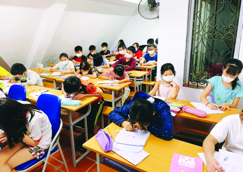 Học sinh lớp Bốn trong một lớp học thêm chật hẹp ở quận Hà Đông, TP Hà Nội ẢNH: U.N