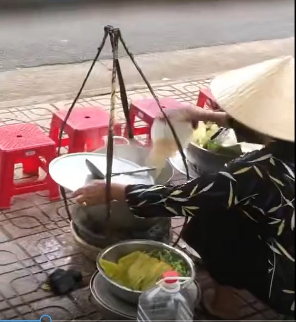 Hình ảnh được cho là người phụ nữ bán hàng rong đổ thức ăn thừa vào nồi nước lèo - Ảnh cắt từ clip