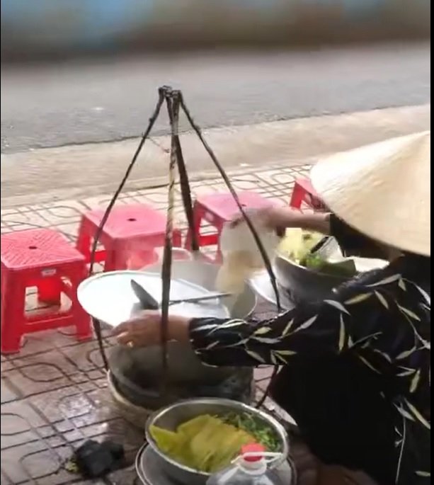 Hình ảnh được cho là người bán hàng rong đổ thức ăn thừa vào nồi nước lèo để bán cho khách đến sau - Ảnh cắt từ clip