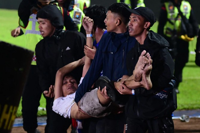 Một nhóm người khiêng một người đàn ông tại Sân vận động Kanjuruhan ở Malang, Đông Java