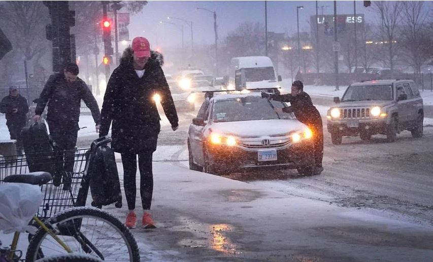 Người đi bộ di chuyển trên vỉa hè phủ đầy tuyết khi nhiệt độ chỉ ở mức một con số vào ngày 22 tháng 12 năm 2022 tại Chicago