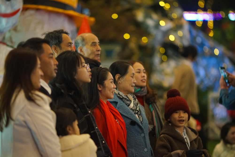 Đại gia đình chụp ảnh lưu niệm đêm Noel với cây thông khổng lồ trước Nhà Thờ Con Gà.