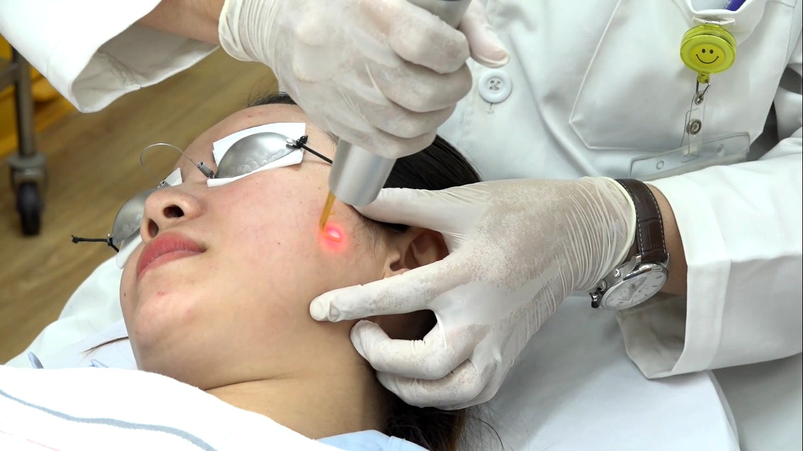 Bác sĩ Phan Ngọc Huy điều trị nám da bằng laser cho người bệnh - Ảnh: P.A.