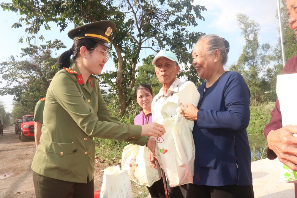 Trung tá Hoàng Thị Lan Phương - Chủ tịch Hội Phụ nữ Phòng Tổ chức cán bộ Công an TP.HCM - tặng quà tết cho bà con xã Tân Nhựt. 