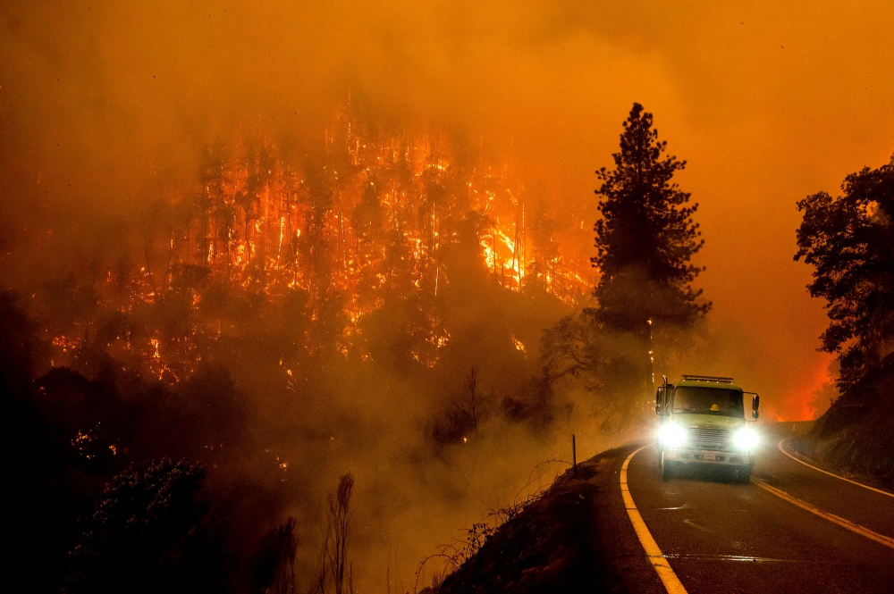 Nắng nóng gay gắt ở Anh, lũ lụt ở Pakistan, cơn bão mùa đông lớn quét qua Mỹ. Ảnh hưởng của thời tiết khắc nghiệt trở nên phổ biến hơn vào năm 2022. Trong ảnh, một chiếc xe cứu hỏa chạy dọc theo Xa lộ California 96 khi Đám cháy McKinney bùng cháy ở Rừng Quốc gia Klamath, bang California (Mỹ) vào tháng Bảy. (Ảnh: AP)