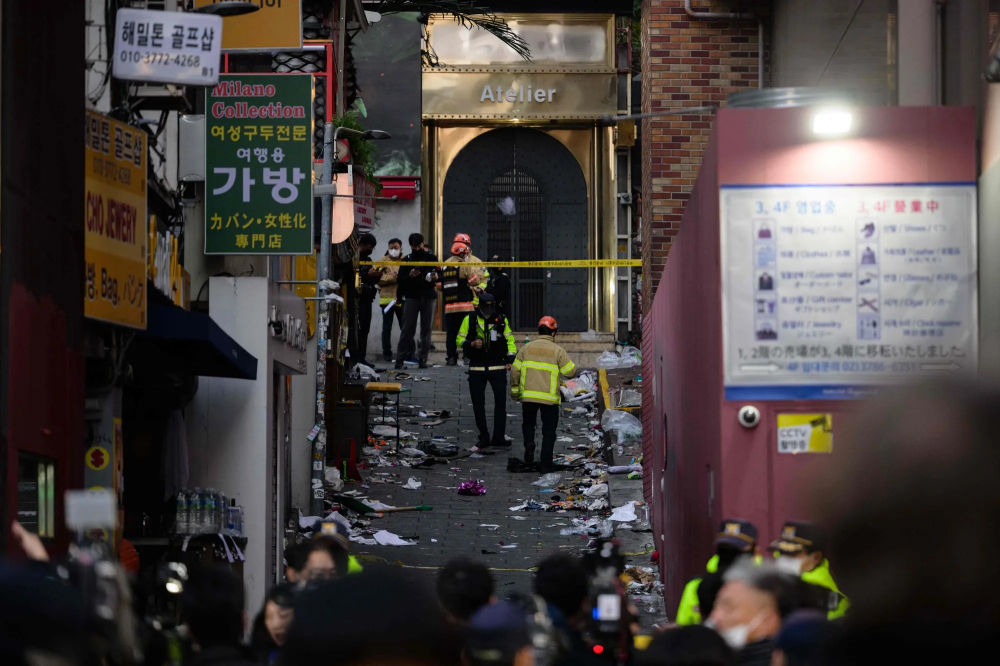 Nhân viên dịch vụ khẩn cấp xem xét con hẻm nơi xảy ra thảm kịch Halloween vào cuối ngày 29/10, tại khu phố Itaewon ở Seoul, Hàn Quốc. Các quan chức cho biết ít nhất 153 người đã thiệt mạng và nhiều người khác bị thương trong vụ đè bẹp tại một sự kiện Halloween đông đúc ở trung tâm Seoul. Đây là một trong những tai nạn tồi tệ nhất của Hàn Quốc sau chiến tranh. (Ảnh: AFP)