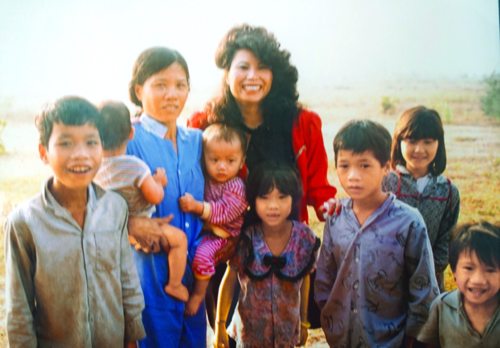 Nhà văn Lệ Lý (giữa) cùng trẻ em mồ côi trong chuyến về thăm Việt Nam những năm 1990  (ảnh tư liệu nhà văn Lệ Lý)