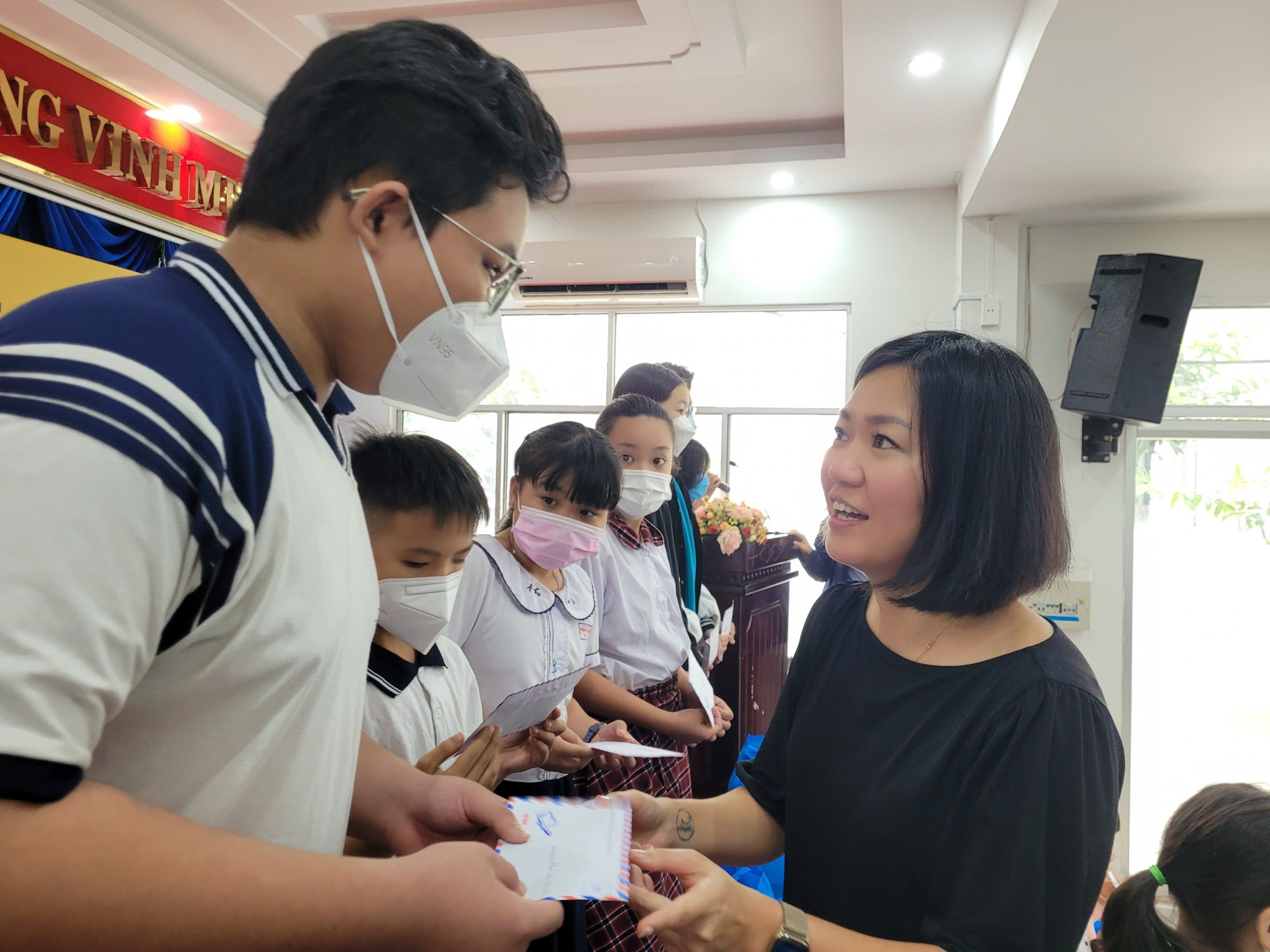 Bà Vũ Ngọc Diễm Hằng - đại diện Nhóm Chung tay vì Việt Nam - trao quà tết cho trẻ em mồ côi vì COVID-19