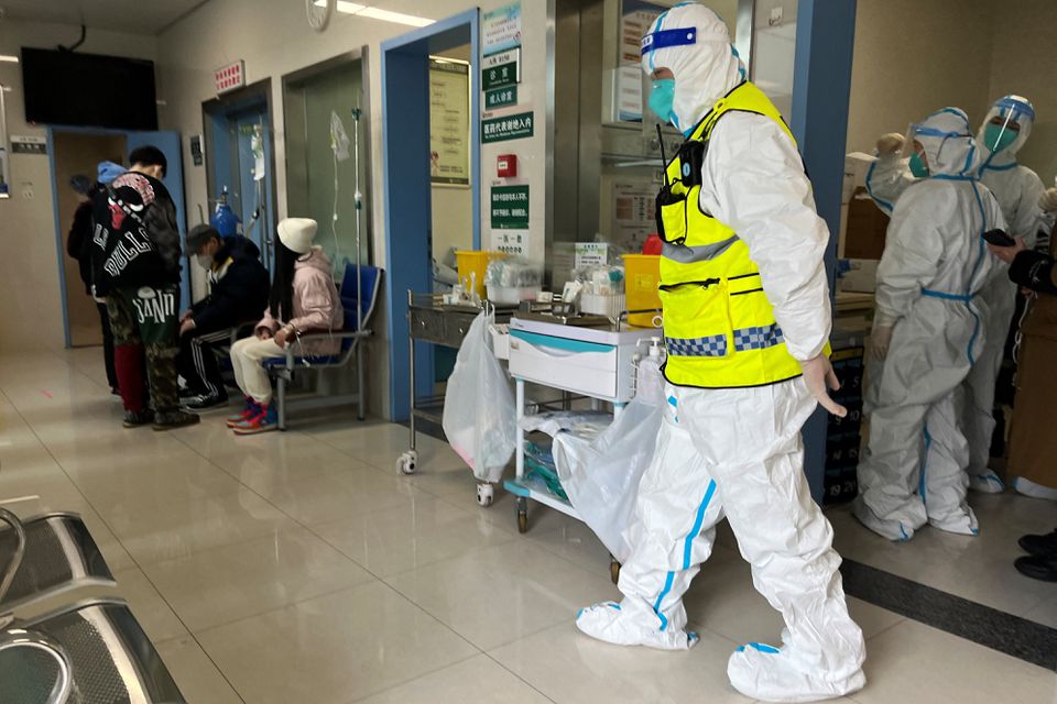 Một nhân viên an ninh trong bộ đồ bảo hộ theo dõi các nhân viên y tế chăm sóc bệnh nhân tại khoa sốt của Bệnh viện Tongji, thành phố Vũ Hán, tỉnh Hồ Bắc