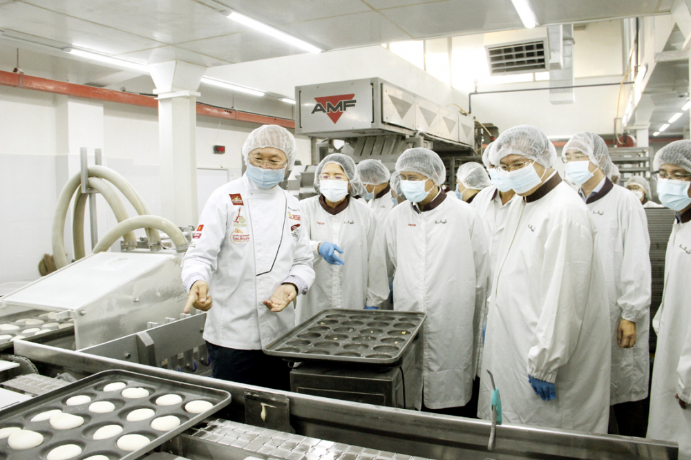 Tham quan xưởng làm bánh ABC là một trong những điểm nhấn của chương trình du lịch “Sắc màu Bình Tân” (trong ảnh: Chủ hiệu bánh ABC Kao Siêu Lực (bìa trái) đang thuyết trình với du khách về quy trình làm bánh mì thanh long từng để giải cứu nông sản Việt trong mùa dịch) - Ảnh: Sơn Vinh