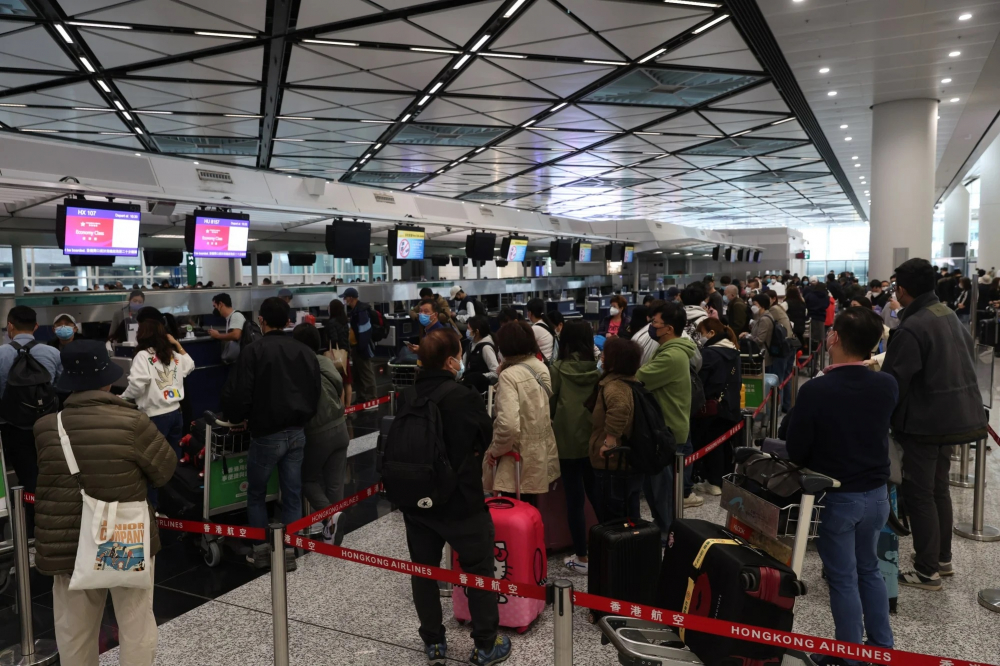 Hành khách xếp hàng làm thủ tục lên máy bay về đại lục tại sân bay quốc tế Hong Kong