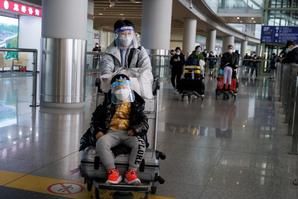 Hành khách đẩy hành lý qua sảnh đến quốc tế tại Sân bay Quốc tế Thủ đô Bắc Kinh, giờ đây họ không còn phải cách ly bắt buộc