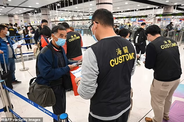 Nhân viên hải quan kiểm tra giấy tờ của một cư dân Hồng Kông khi người này băng qua biên giới vào Trung Quốc đại lục