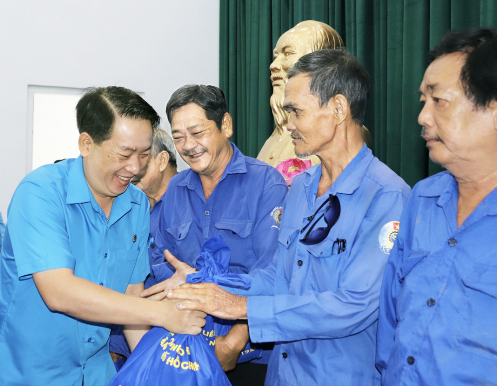 Đại diện Liên đoàn Lao động TPHCM tặng quà chăm lo tết đoàn viên nghiệp đoàn xe ôm - Ảnh: Thái Phương