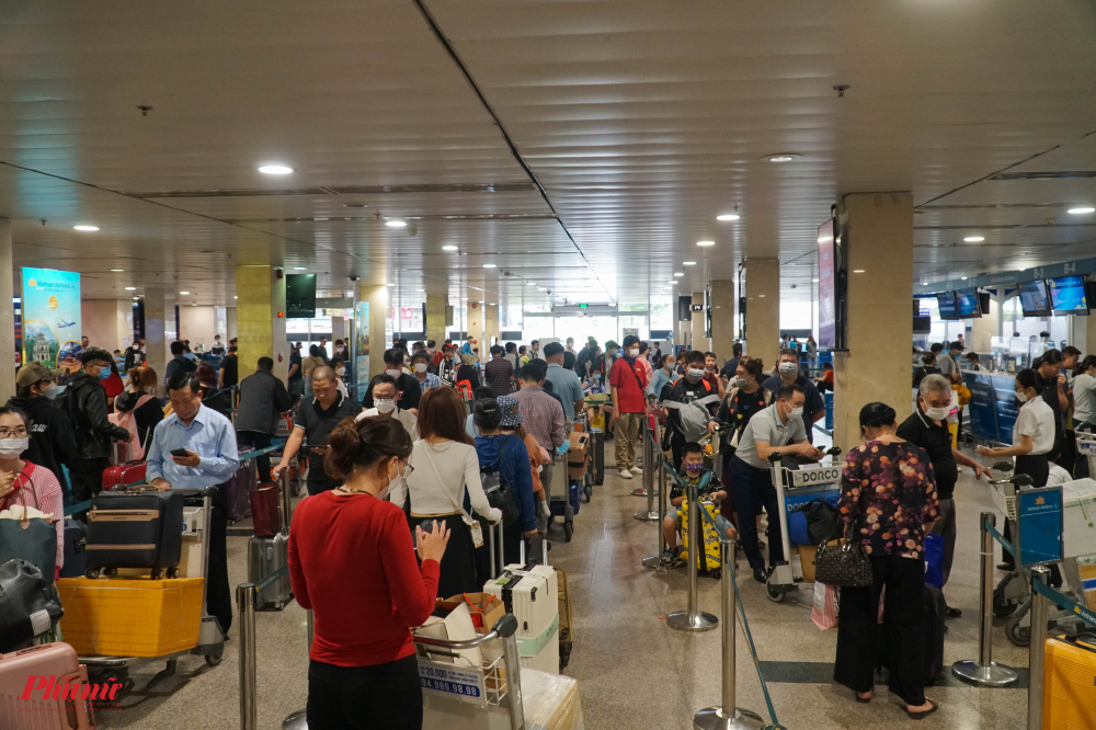 Càng về chiều, khách càng đông tại các quầy làm thủ tục của các hãng hàng không để rời TPHCM về quê. (Trong ảnh: Khách đến sớm sếp hàng zit