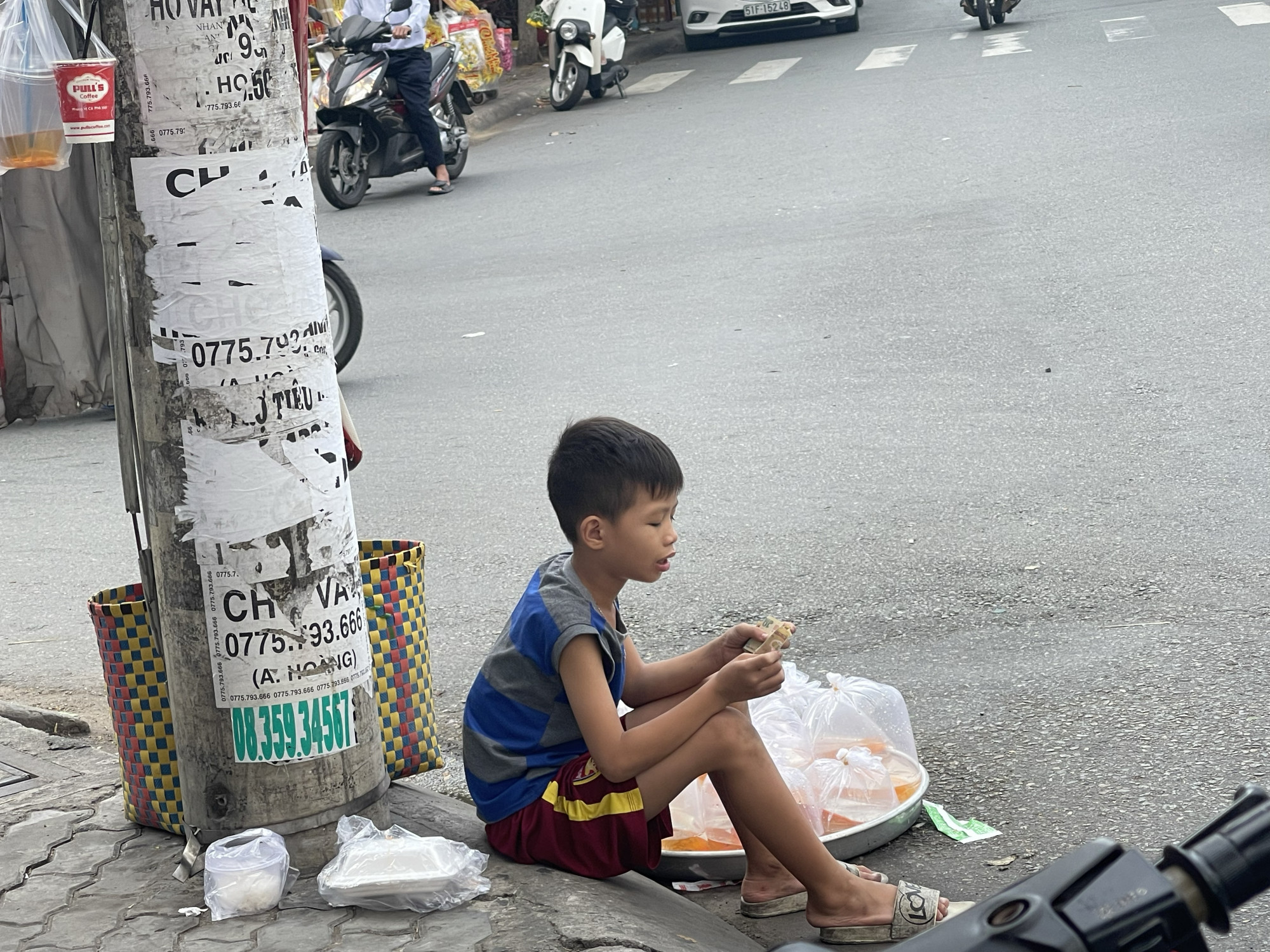 Một cậu bé ngồi bán cá chép để tiễn ông Táo về trời.