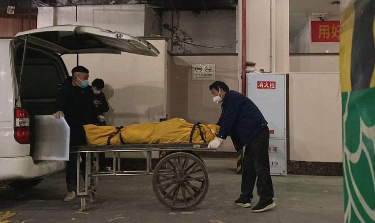 Nhân viên tang lễ đưa thi thể lên xe đẩy để hỏa táng tại lò hỏa táng ở Trùng Khánh, Trung Quốc, vào ngày 22/12/2022. ẢNH: AFP