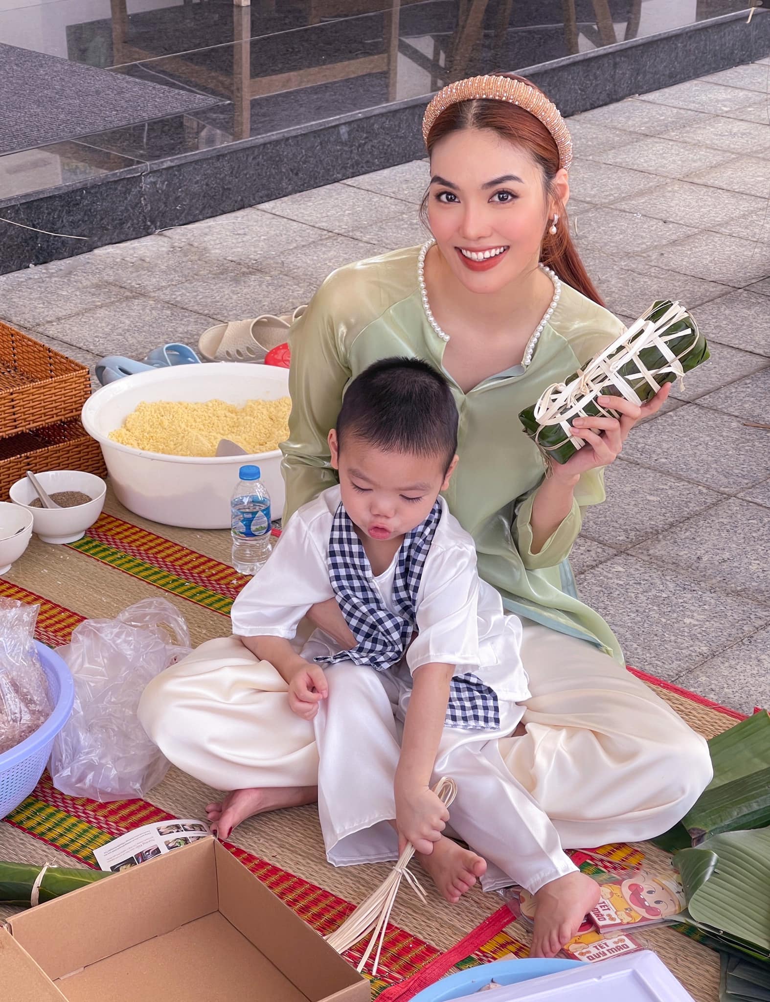 Hoa khôi, siêu mẫu Lan Khuê cùng con trai gói bánh để đón tết. 