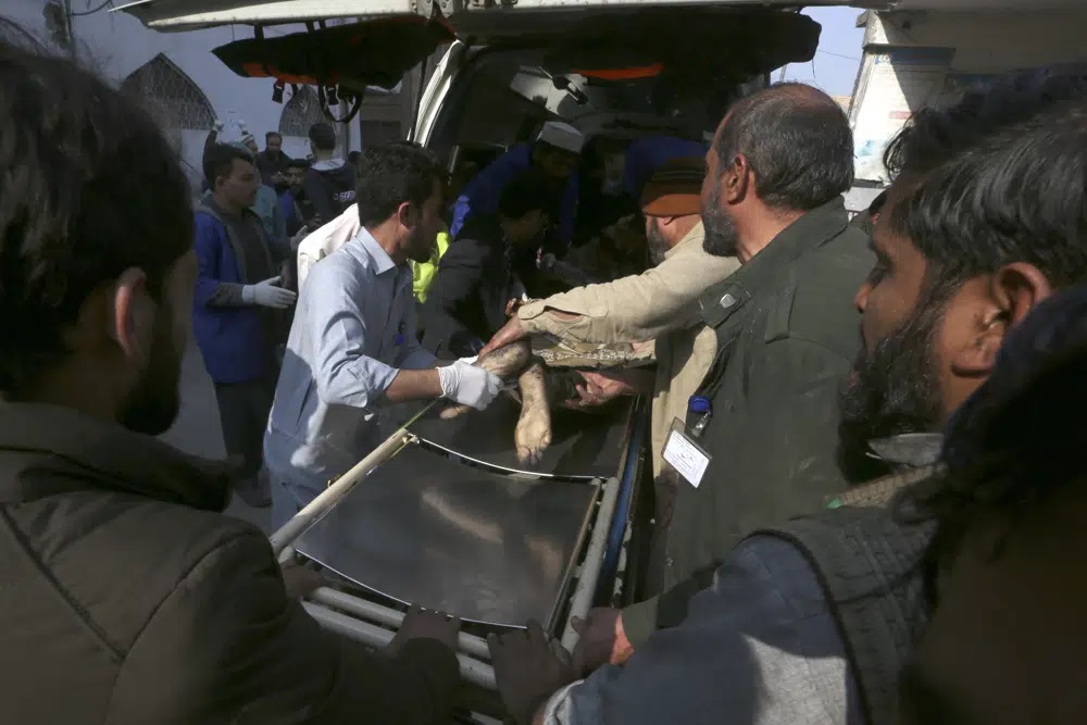 Nhân viên bệnh viện và tình nguyện viên đưa một nạn nhân bị thương trong vụ đánh bom tự sát ra khỏi xe cứu thương khi đến bệnh viện ở Peshawar, Pakistan