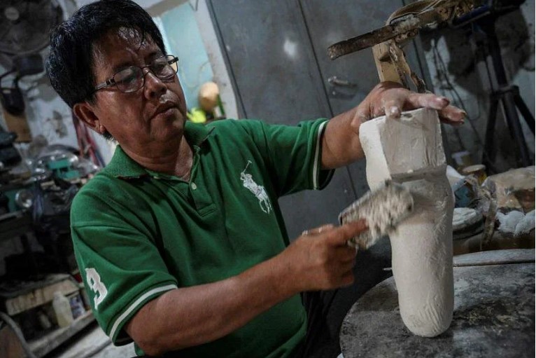 Ông Ali Saga làm chân tay giả trong xưởng của mình ở Tangerang để giúp đỡ người khuyết tật. ẢNH: AFP