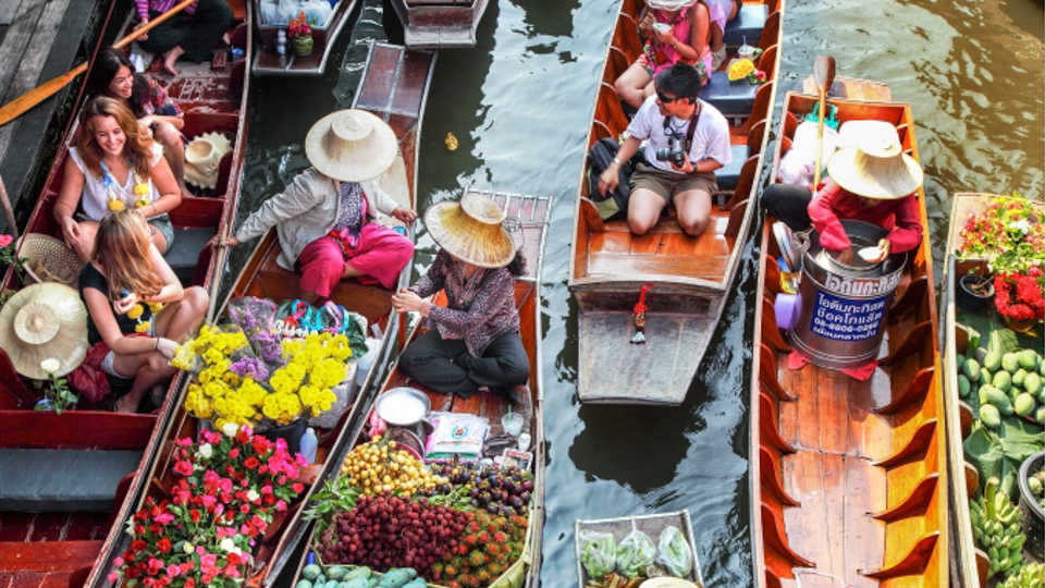 CHỢ NỔI, RATCHABURI, THÁI LAN Chợ nổi Damnoen Saduk, Thái Lan - 03/04/2011: Người bán thực phẩm tại Chợ nổi Damnoen Saduk chuẩn bị món mì kiểu Thái trên một chiếc thuyền truyền thống.  Nhiều nguyên liệu tươi được sử dụng và sự kết hợp tổng thể của các hương vị rất ngon.  tín dụng: istock sử dụng một lần chỉ dành cho Khách du lịch Ảnh: iStock  Chợ sông sáng sớm này cách Bangkok 100 km rất sống động và đầy màu sắc. Nếu bạn không biết khế, bưởi Trung Quốc hay zirzat là gì, đã đến lúc thưởng thức vị giác của bạn. Những bếp nổi trôi qua với những món mì xào giòn với tôm, mãng cầu dừa nấu trong những quả bí ngô nhỏ và những chiếc bánh dừa gói trong những chiếc lá chuối gọn gàng.