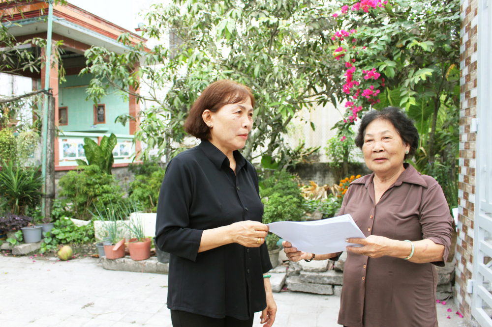Bà Lê Thị Ngọc Tâm (bìa phải) đến tận nhà dân vận động hiến đất, mở rộng hẻm