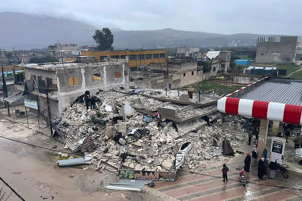 Người dân và nhân viên cứu hộ gấp rút đào bới đống đổ nát của một tòa nhà bị sập ở thị trấn Azmarin, thuộc tỉnh Idlib, miền bắc Syria