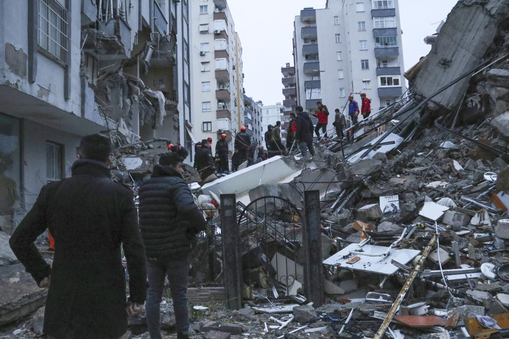 Người dân và đội cứu hộ cố gắng tiếp cận những cư dân bị mắc kẹt bên trong các tòa nhà bị sập ở Adana, Thổ Nhĩ Kỳ