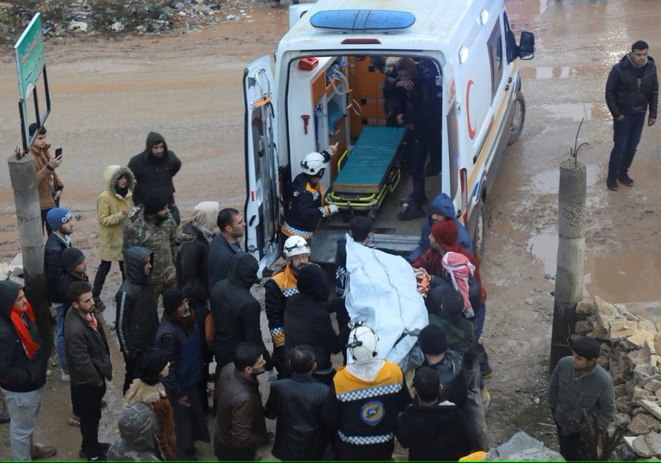Lực lượng cứu hộ đưa nạn nhân lên xe cứu thương tại hiện trường nơi một tòa nhà bị hư hại, sau trận động đất, ở Azaz, Syria