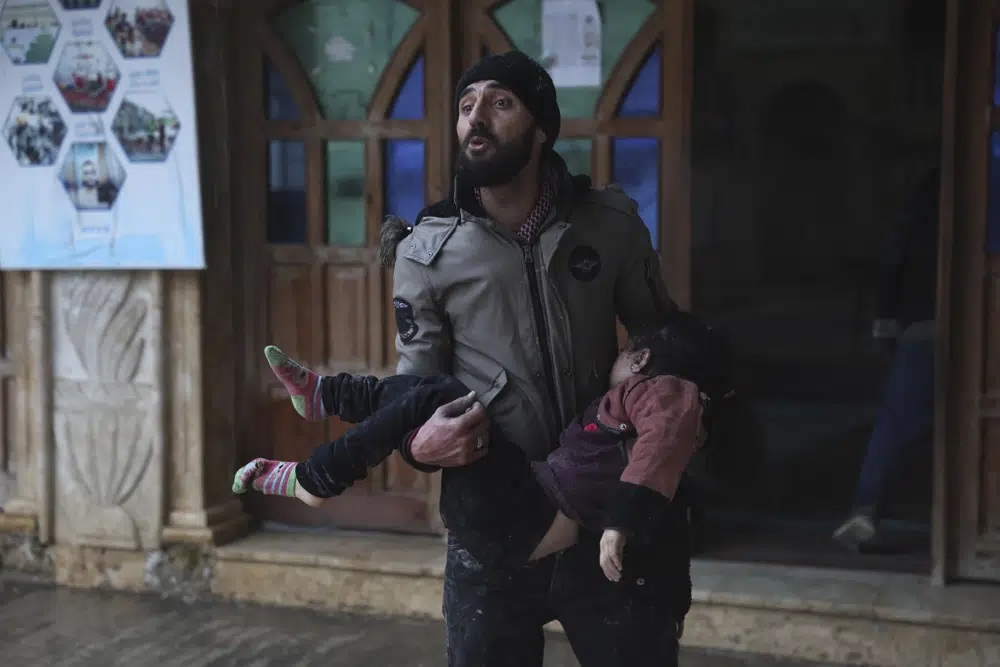 Một người đàn ông bế thi thể một bé gái tại thị trấn Azmarin, tỉnh Idlib phía bắc Syria